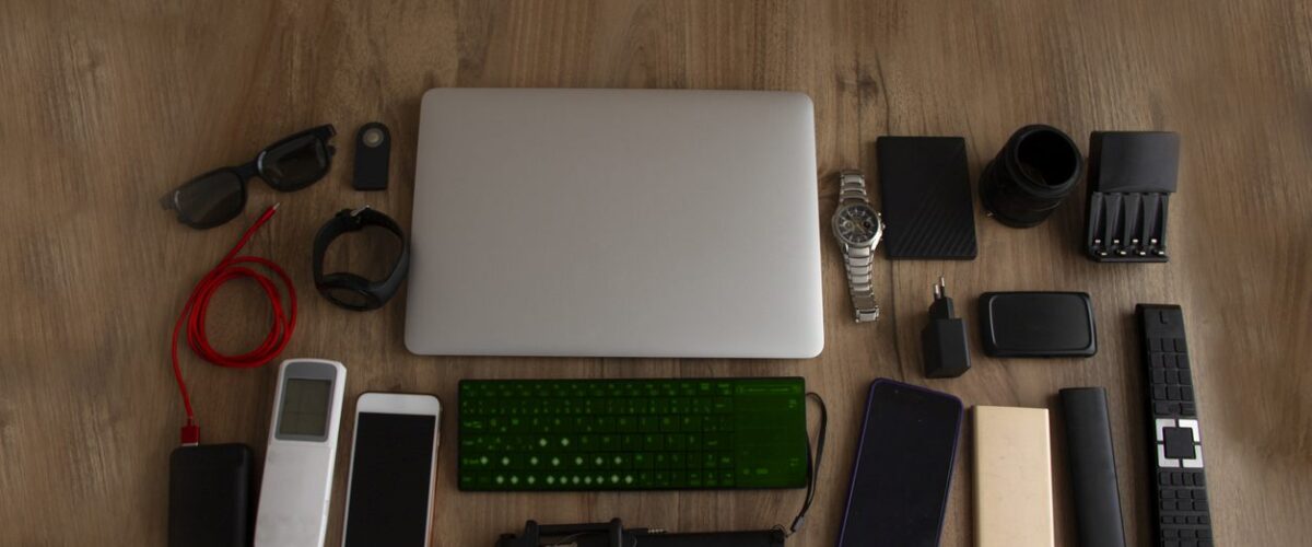 An assortment of electronic devices set on a wooden surface.