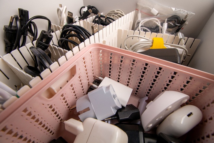 Some neatly packed wires and electronic devices are organized and stored in dedicated spaces.